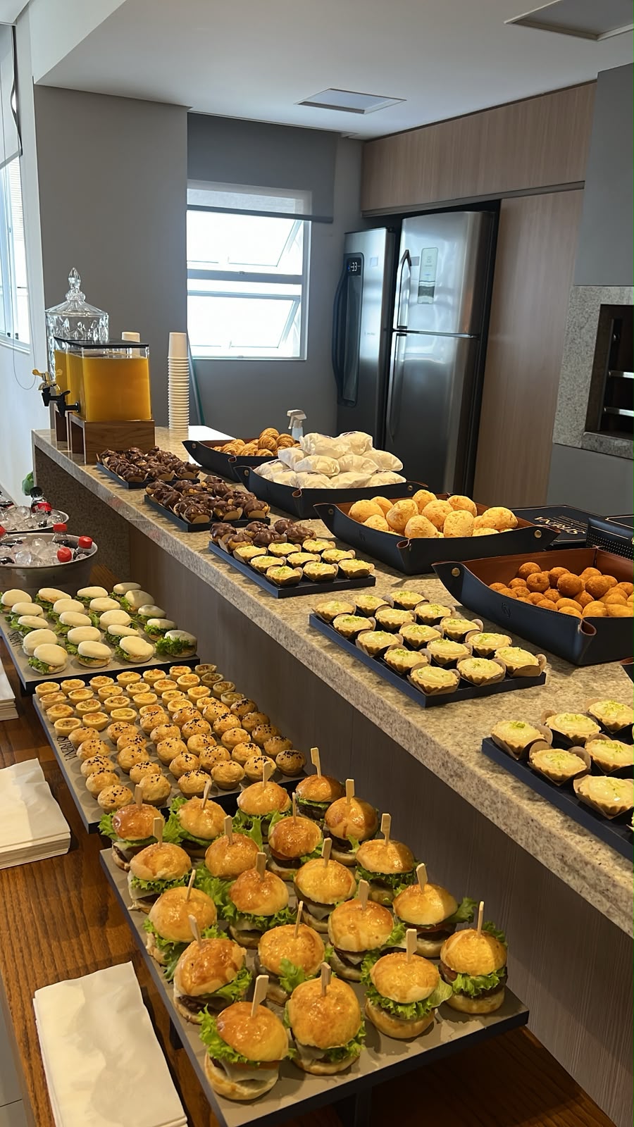 Mesa de coffee break montada pela STRENA com mini lanches, salgados, doces e bebidas